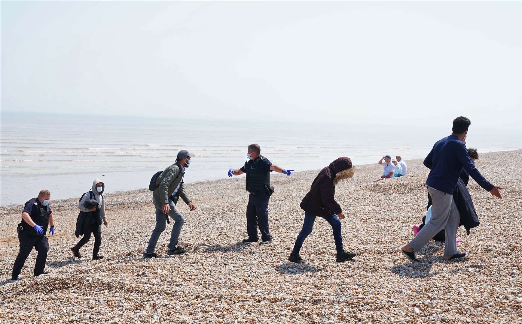 People are escorted from the beach in Dungeness, Kent (Gareth Fuller/PA)