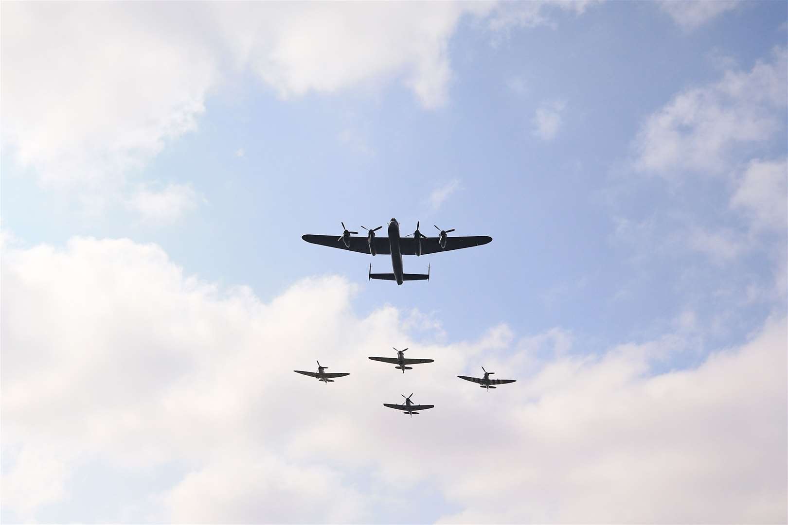 Three Spitfires, a Hurricane and a Lancaster bomber fly over the service (Peter Byrne/PA)