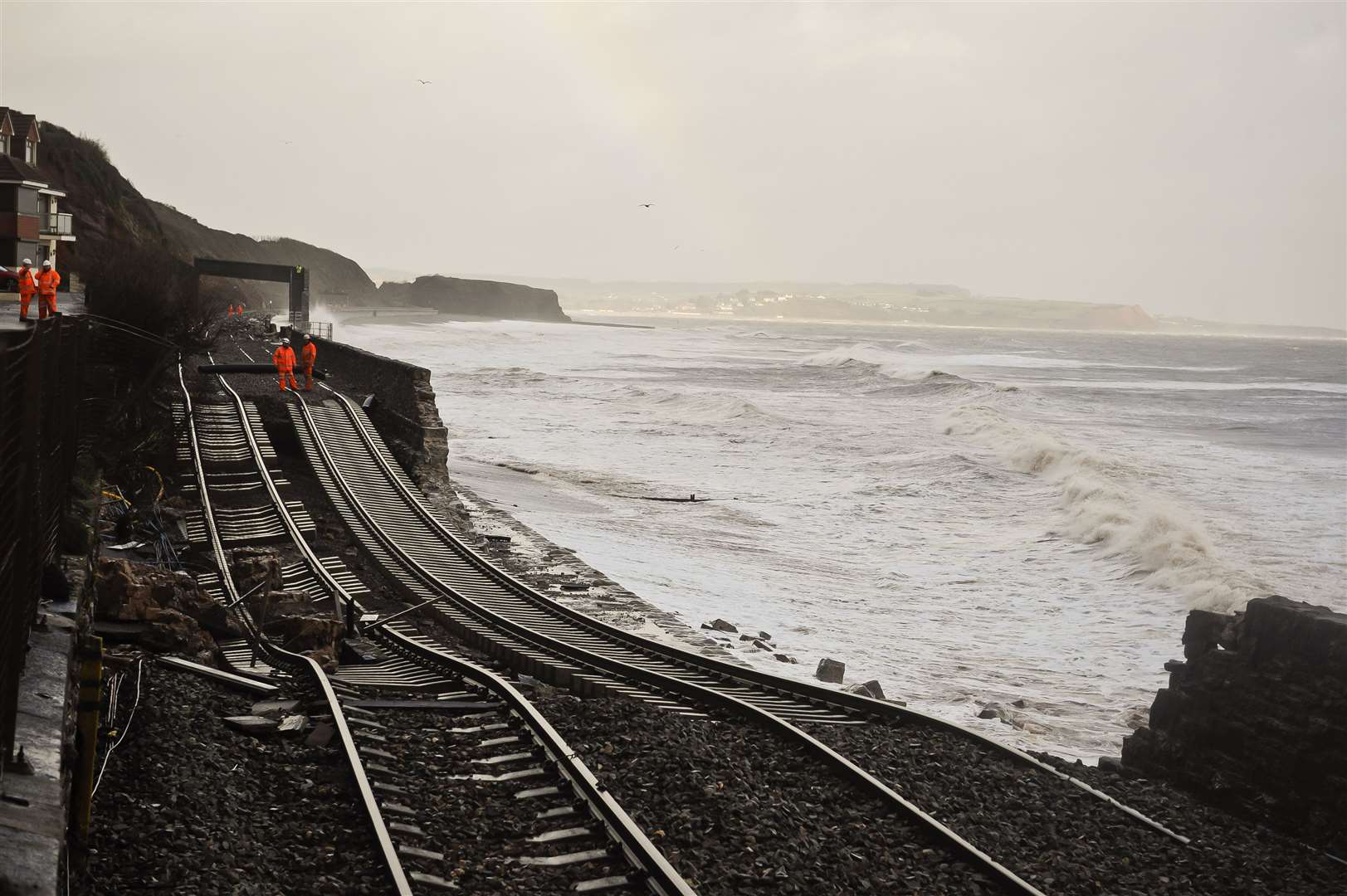 A huge length of railway track is exposed and left hanging after the sea wall collapsed in Dawlish in 2014 (Ben Birchall/PA)