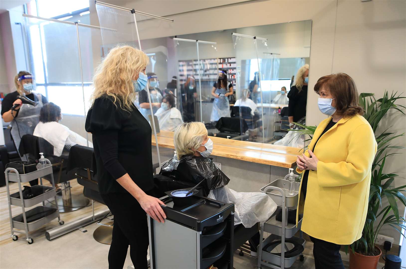 Martine Broggy (left) and customer Lorraine Calvert chat with Economy Minister Diane Dodds (Peter Morrison/PA)