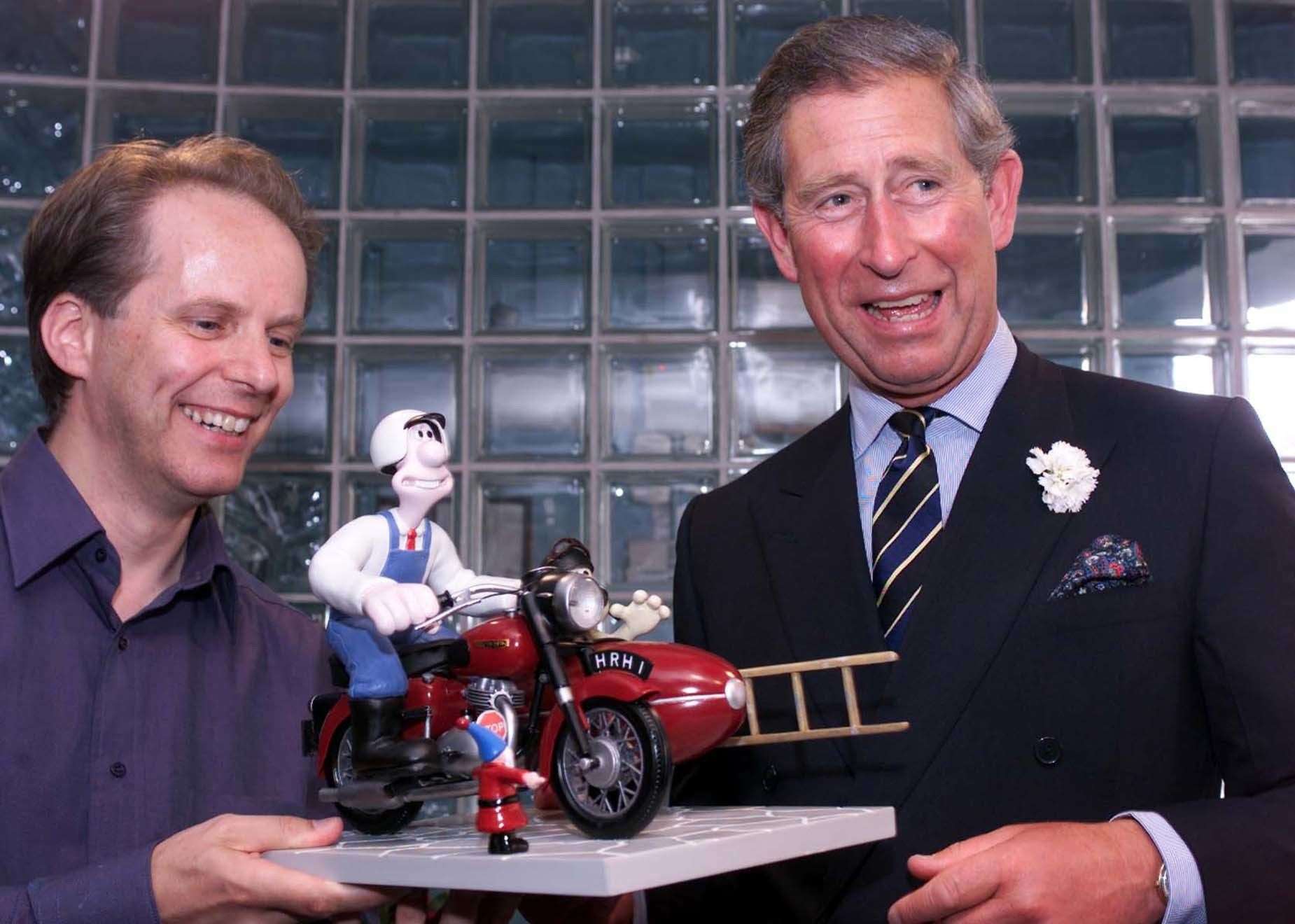 The then-Prince of Wales accepted a model of animated characters Wallace and Gromit from Aardman creator Nick Park in 2001 (PA)