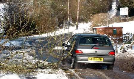 This motorist at Speldhurst, near Tunbridge Wells, had to negotiate his way around fallen branches. Picture: MATT WALKER