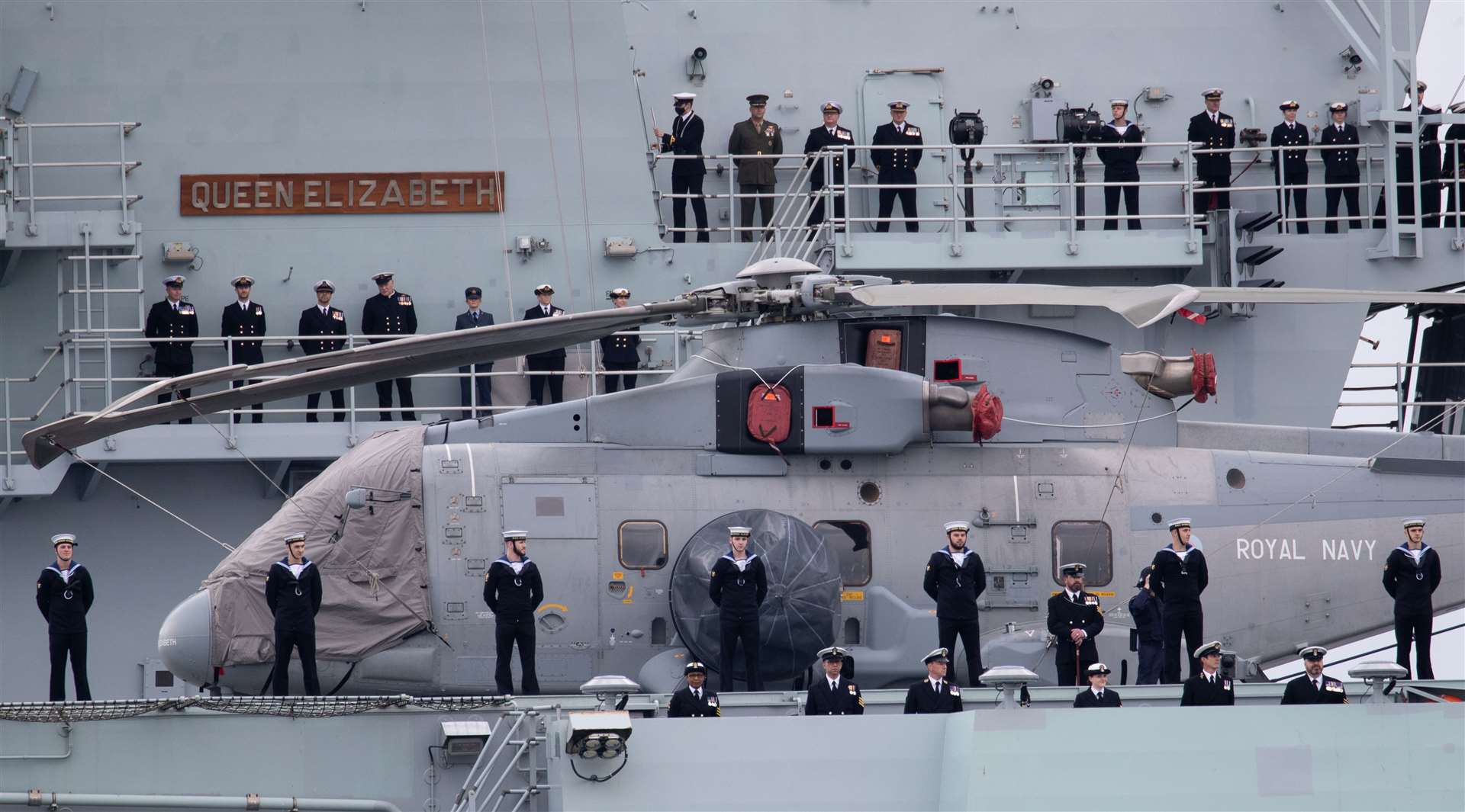 The ship’s company line the side of the Royal Navy aircraft carrier HMS Queen Elizabeth (Andrew Matthews/PA)