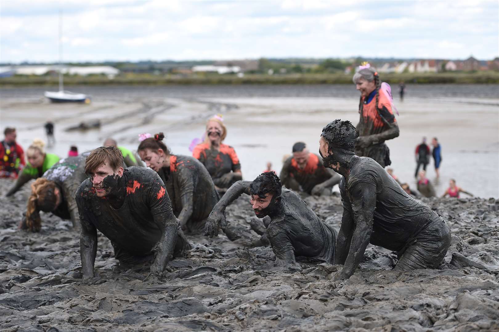 Competitors take part in the annual Maldon mud race, a charity event to race across the bed of the River Blackwater in Maldon, Essex (PA)