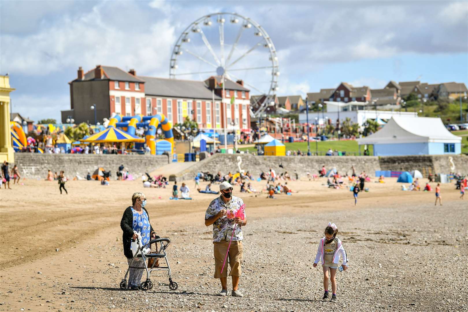 People walk along Barry Island beach in Wales in early August (Ben Birchall/PA)