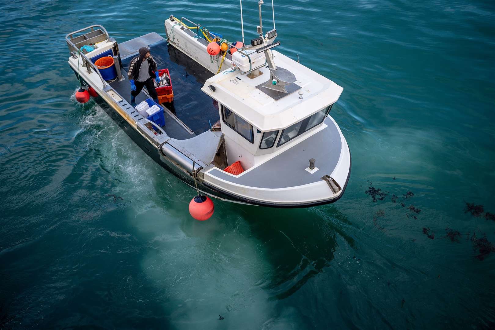 A fishing boat reverses after unloading a catch at the harbour in St Helier, Jersey (Ben Birchall/PA)