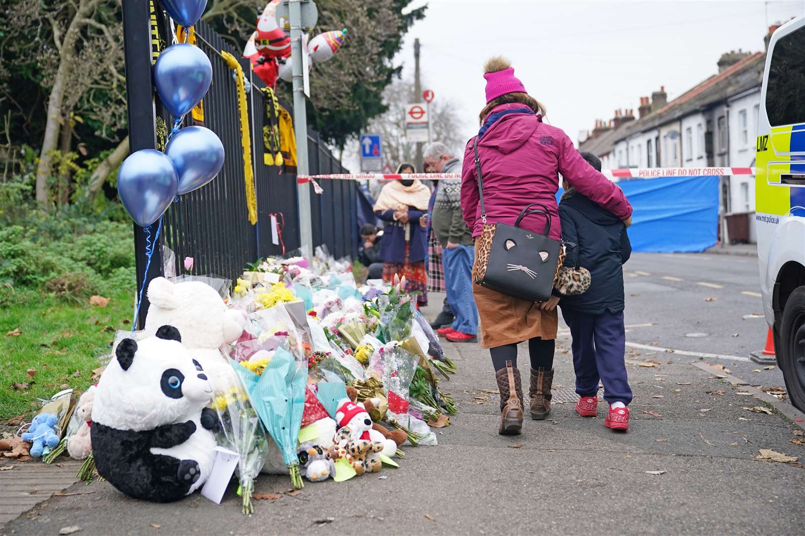 Flowers and toys are left near the scene of the fatal fire in Sutton, south London (Yui Mok/PA)