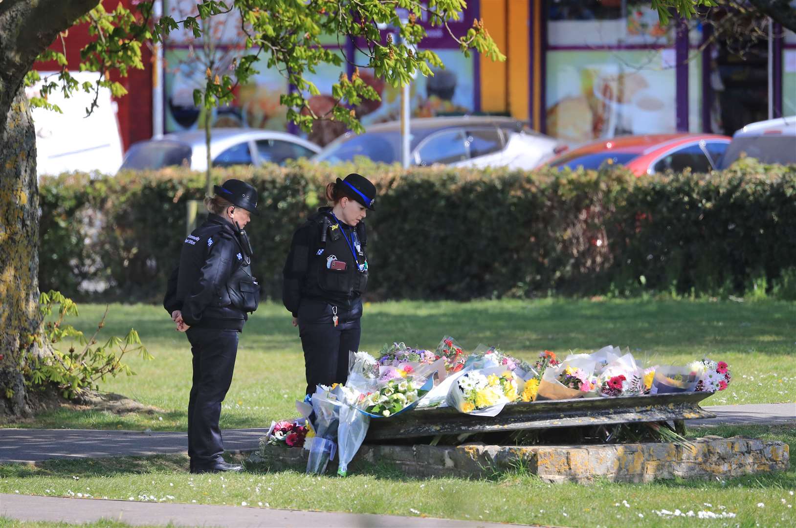 Police community support officers look at flowers left in memory of PCSO Julia James in Aylesham, Kent (Gareth Fuller/PA)