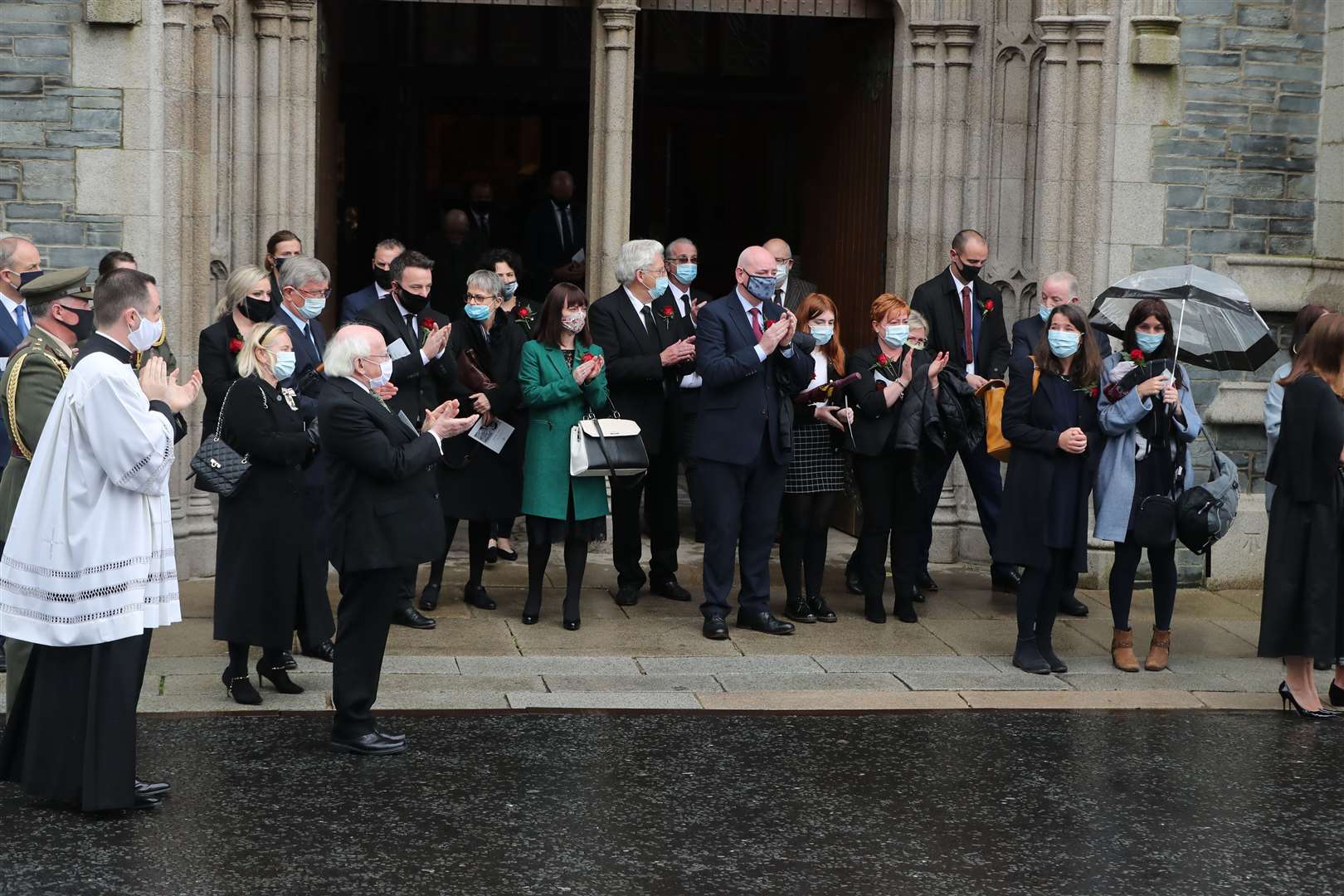 Mourners including Irish President Michael D Higgins clap as John Hume’s coffin leaves St Eugene’s Cathedral ( Niall Carson/PA)