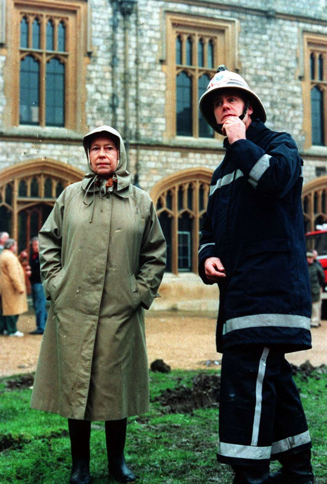 Queen Elizabeth II inspects the ruins of Windsor Castle with a fireman in 1992 (Tim Ockenden/PA)