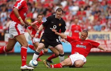 Charlton's Luke Young slides in on Wayne Rooney. Picture: MATT WALKER