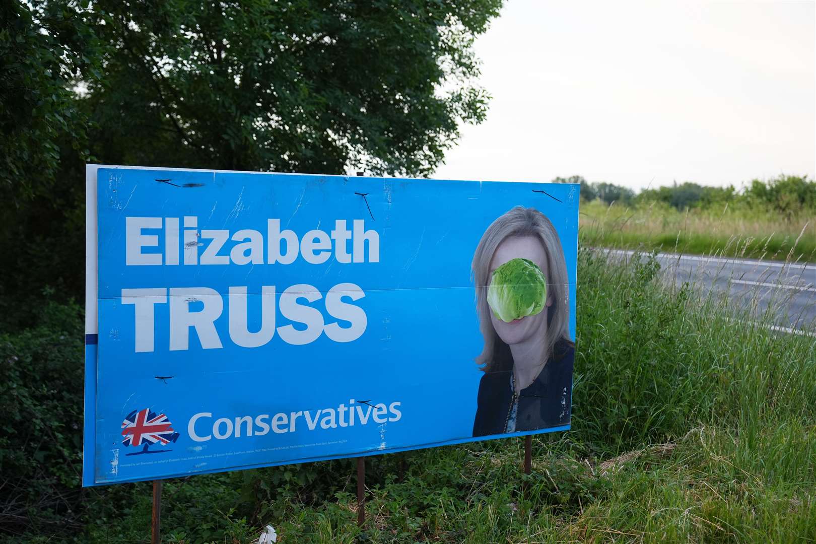 A lettuce covers the face of Liz Truss on a campaign advertising board on the A47 near Wisbech, during the 2024 General Election (Jacob King/PA)