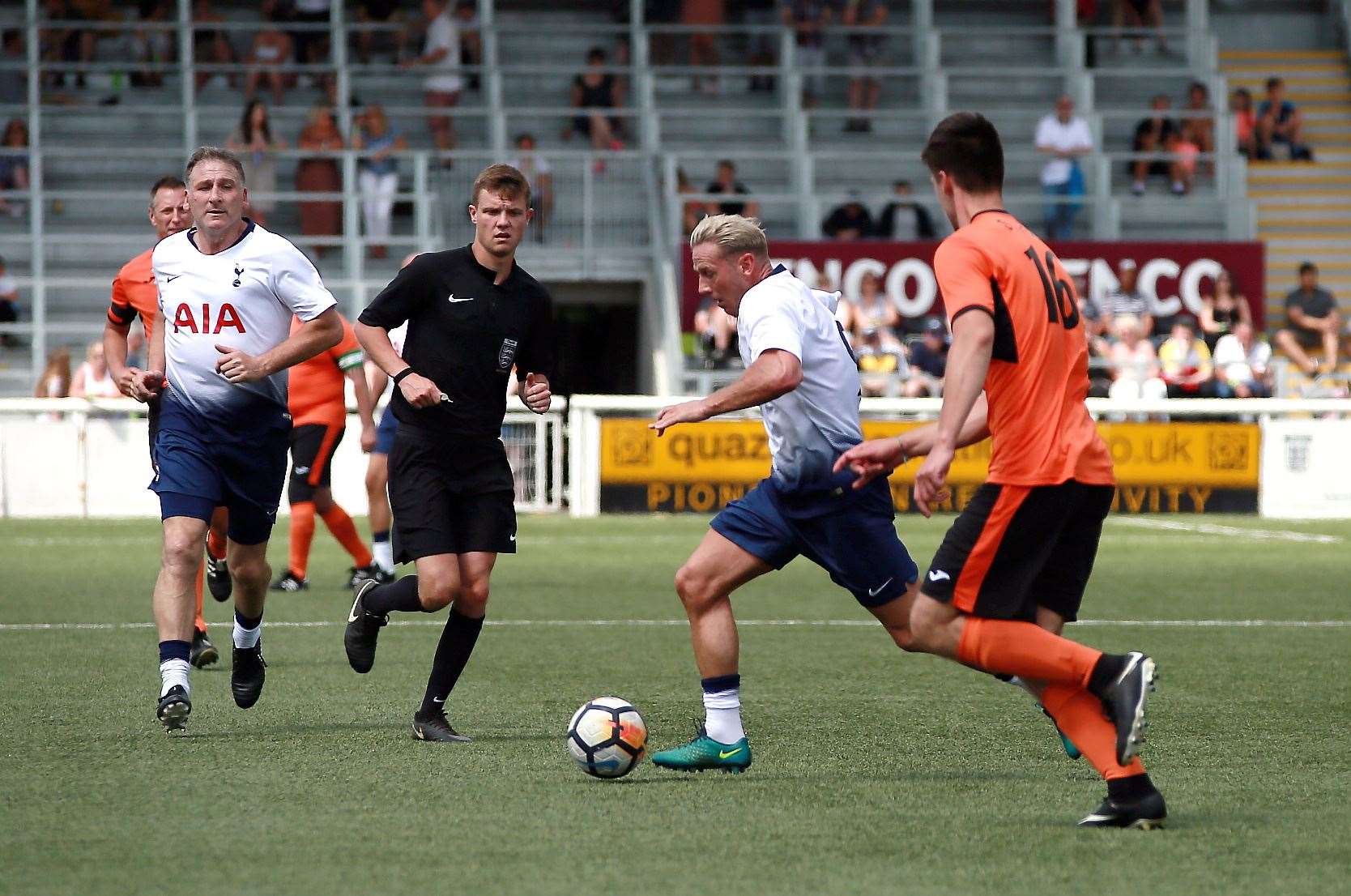 Action from the game between Spurs Legends in white and Waitrose in orange