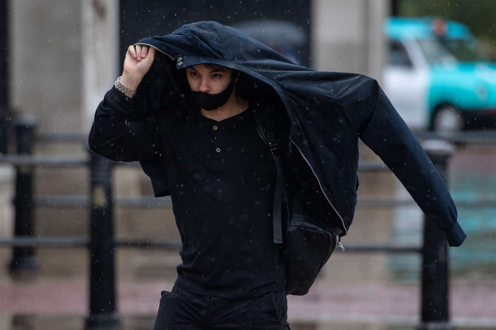 A man shelters from the rain under his jacket outside Buckingham Palace in central London, as wet weather struck the UK ahead of the arrival of Storm Ellen (Dominic Lipinski/PA)