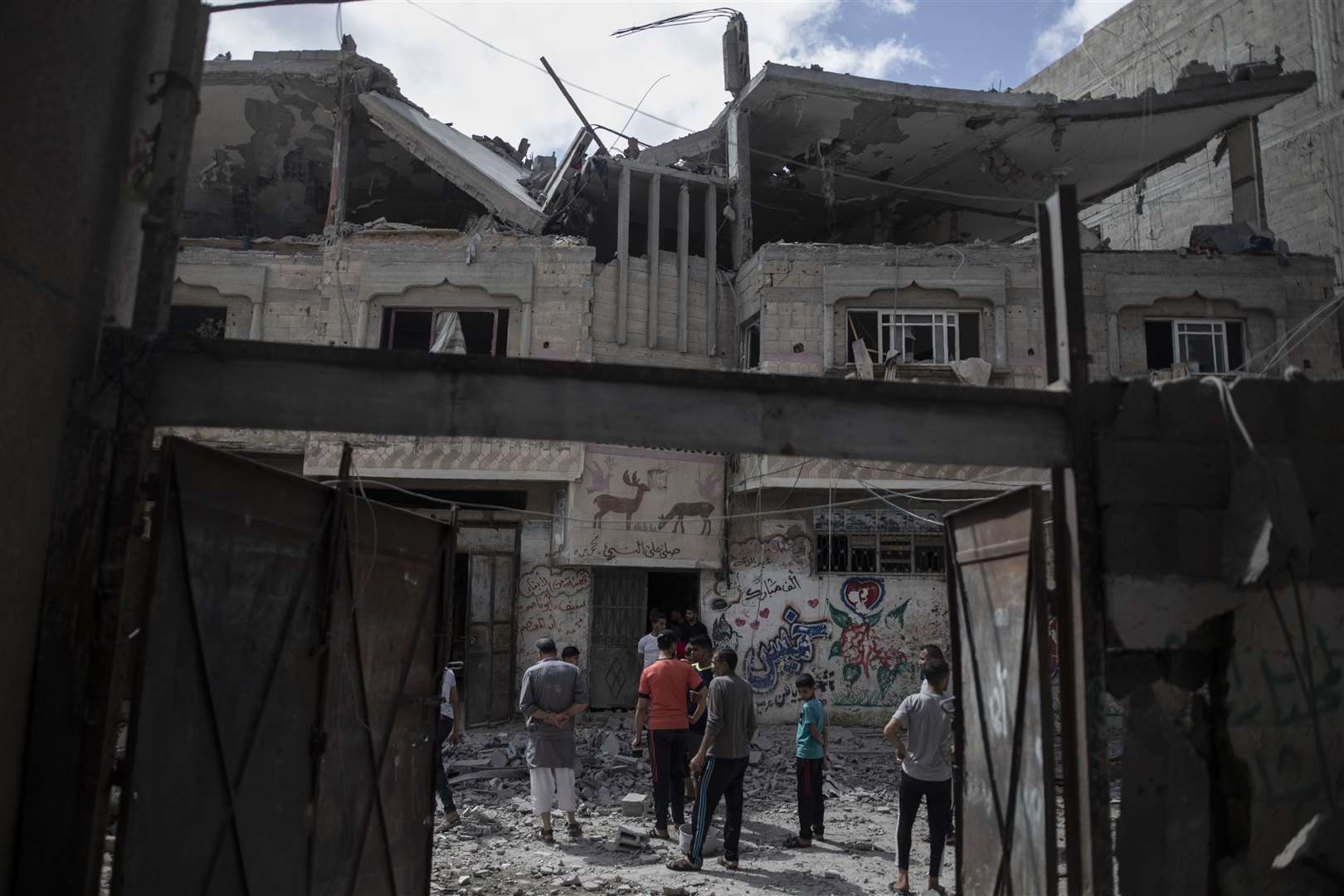 Palestinians inspect a damaged house that was hit by early morning Israeli airstrikes, in Gaza City (Khalil Hamra/AP)