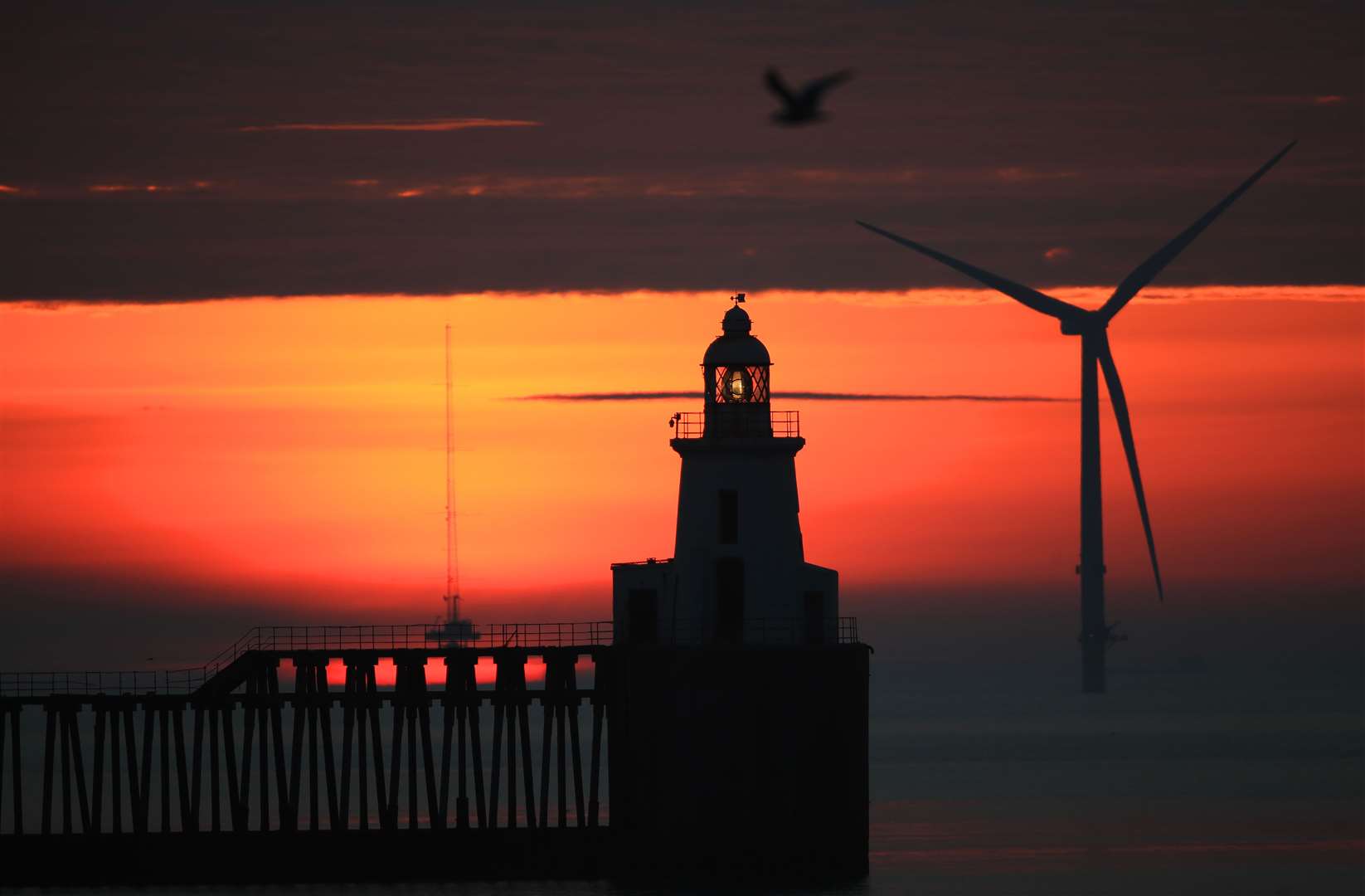 Sunrise at Blyth Pier in Northumberland heralded the sunny skies ahead (Owen Humphreys/PA)