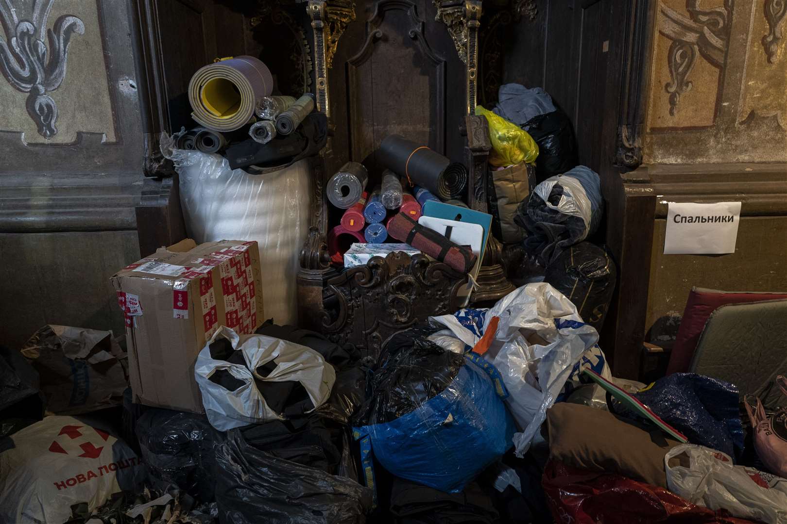 Clothes donations and sleeping pads are stored inside a church in Lviv (Bernat Armangue/AP/PA)