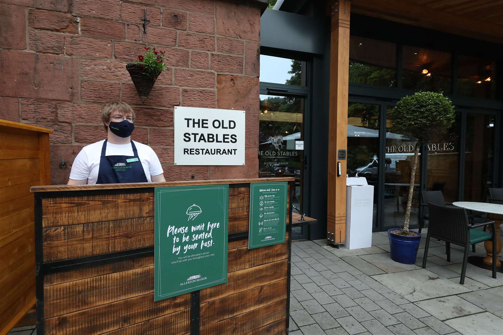 In Liverpool, a member of staff in PPE waited for customers at the reopening of The Old Stables Restaurant at Allerton Manor Golf Club (Peter Byrne/PA)