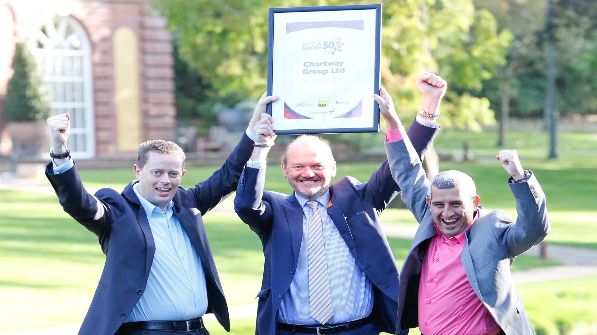 From left, Chartway Group directors Stuart Mitchell, Philip Cunningham and Paul Safa raise their arms in 2014