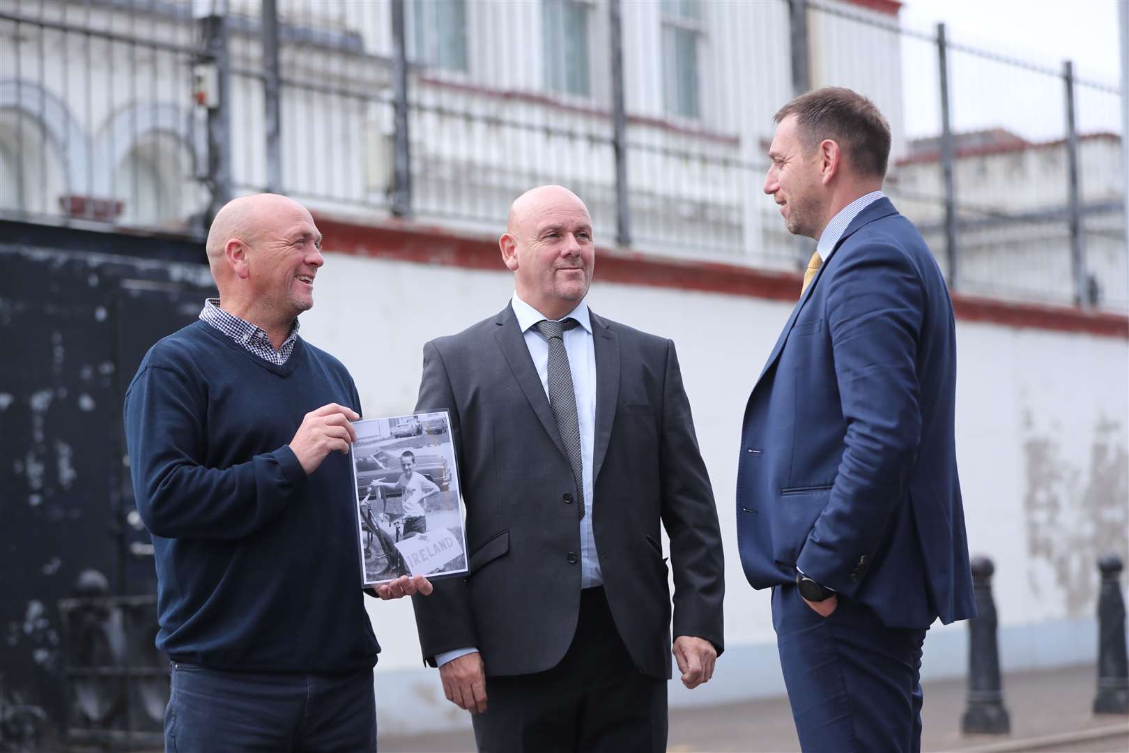 Joe (left) and Kieran Geddis talk with their solicitor Padraig O’Muirigh (right) as they hold a picture of their brother Stephen, who died aged 10, in 1975, outside Banbridge Court House where a fresh inquest into his death is being held (Niall Carson/PA)