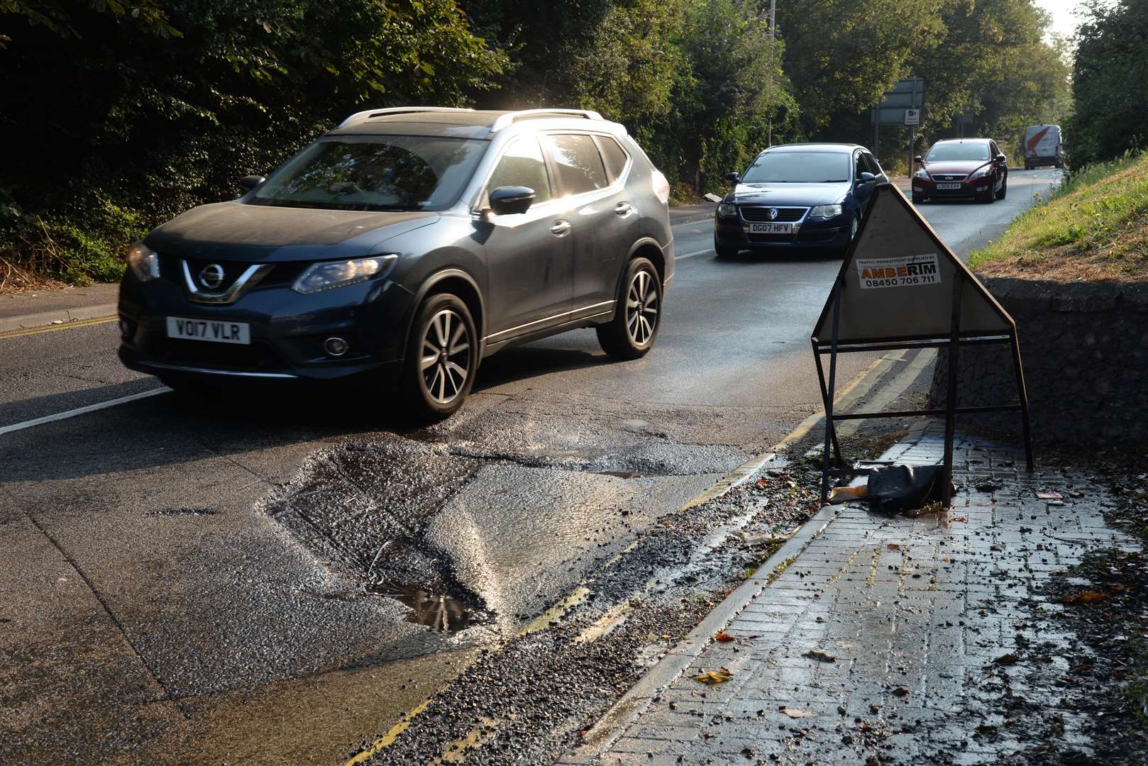 The hole and water leak outside St Mary's Church in London Road, Greenhithe