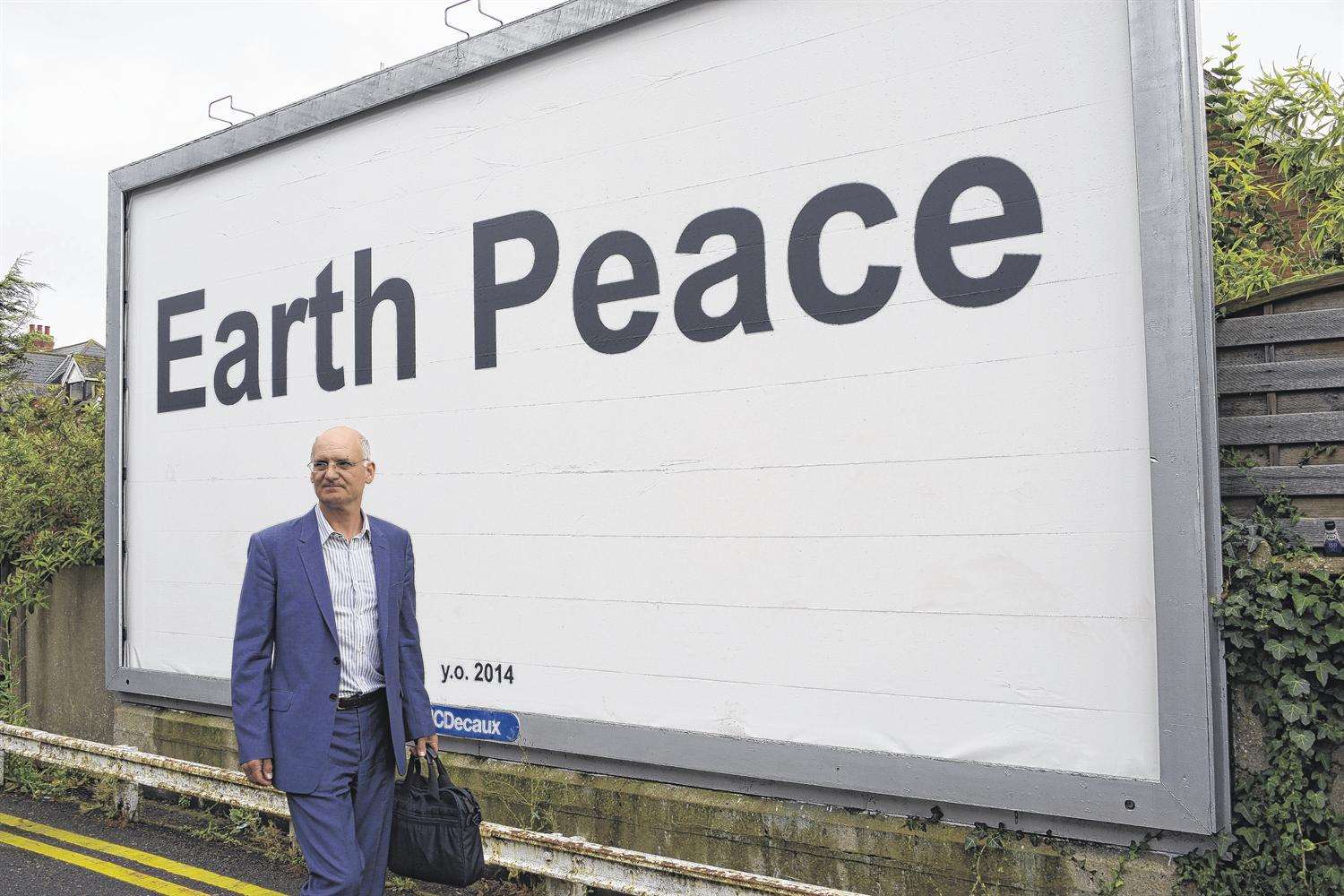 Folkestone Triennial curator Lewis Biggs walks past the text exhibit by Yoko Ono