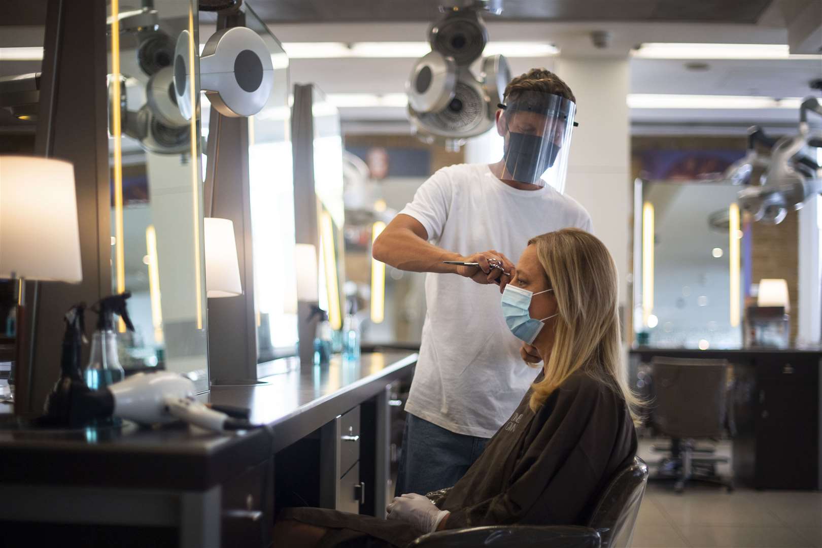 A staff member wears correct PPE as he cuts hair at Daniel Galvin hairdressers in Marylebone, London (Victoria Jones/PA)