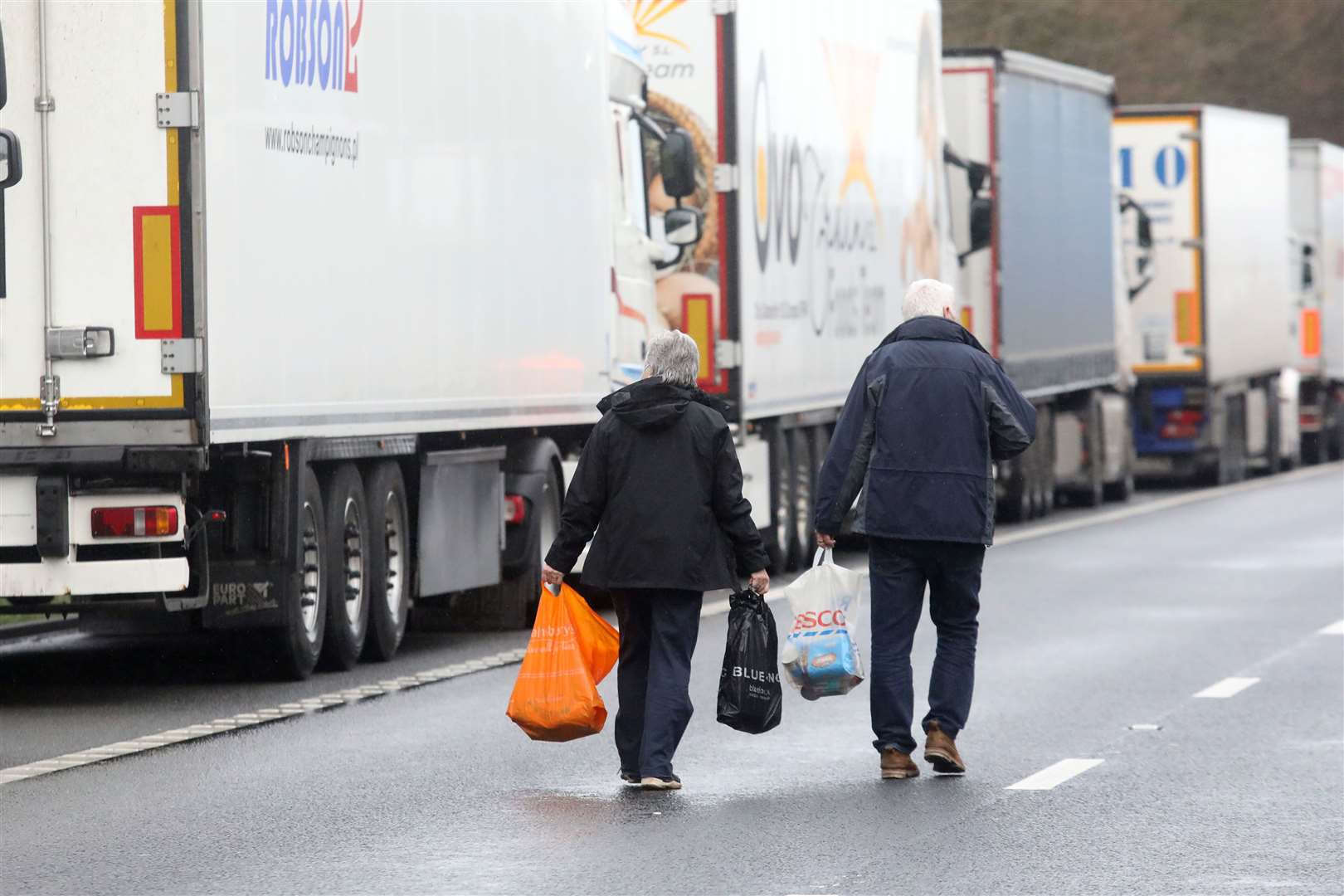 While some villagers have lowered food from the bridges, David and Jan James walked along the M20 to dish out donations to truckers. Picture: Barry Goodwin