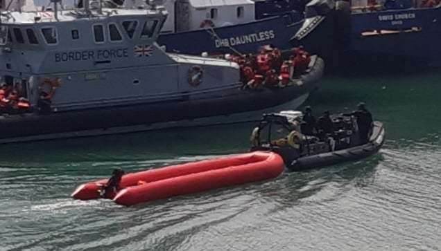 An empty dinghy is towed into Dover Marina following a large group of people being brought ashore by Border Force. Picture: Sam Lennon