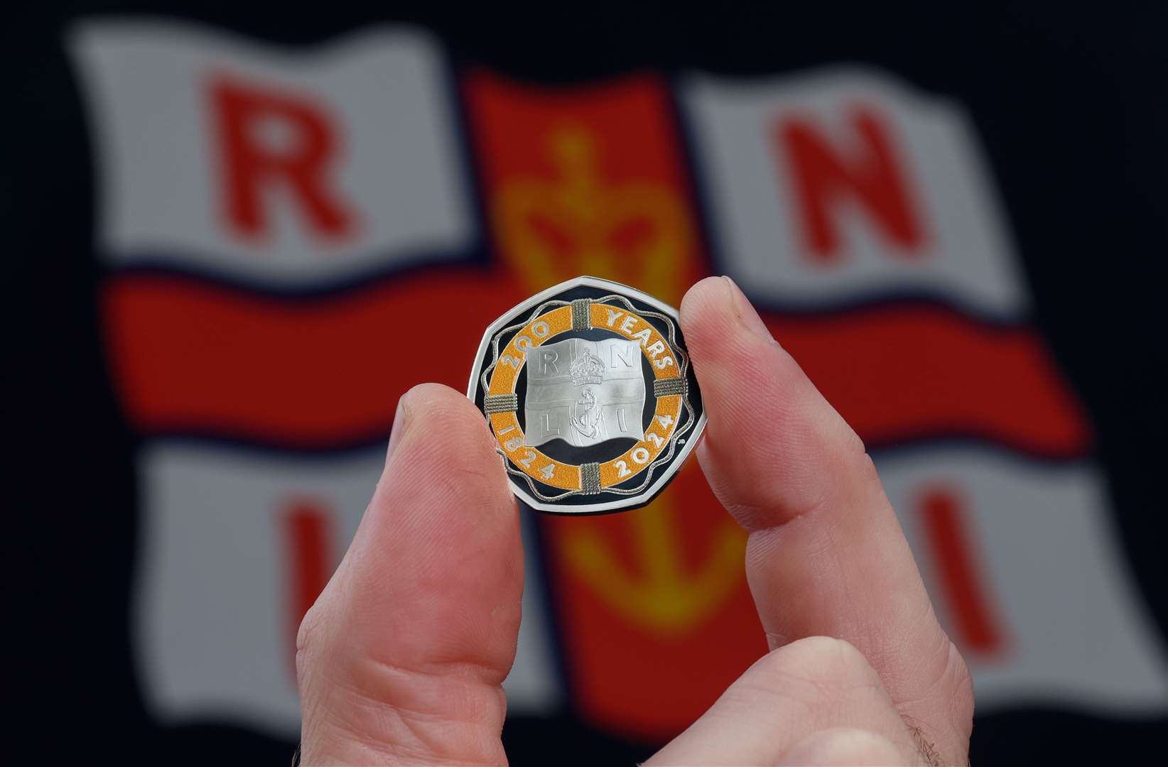 The orange colour of the coin has been carefully matched to the colours of the RNLI. Image: The Royal Mint.