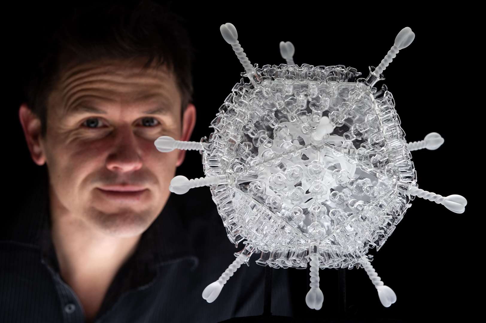 Luke Jerram pictured next to his glass sculpture of the Oxford/AstraZeneca vaccine (Andrew Matthews/PA)