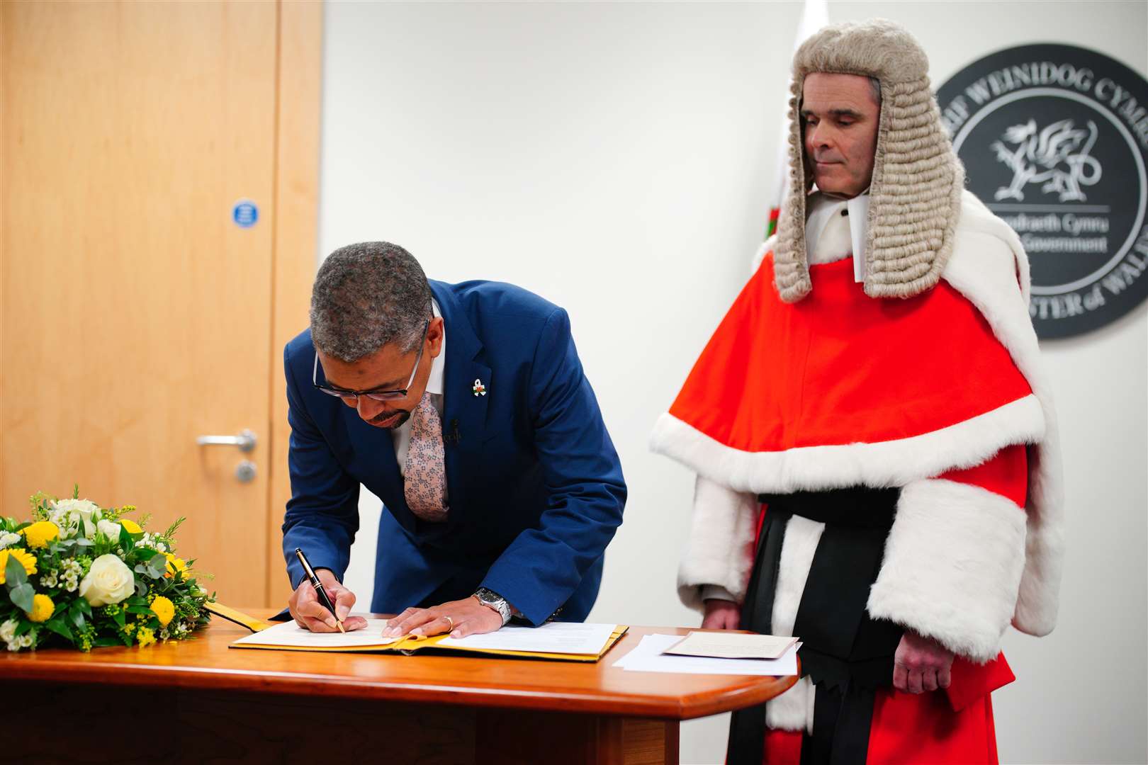 Vaughan Gething signs his affirmation as the first minister of Wales, watched by Justice Martin Griffiths, but within weeks the politician was forced to quit (Ben Birchall/PA)