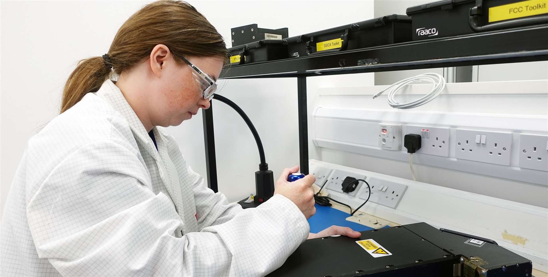 Emily Chad fitting and torqueing a power supply unit to a flight control computer.