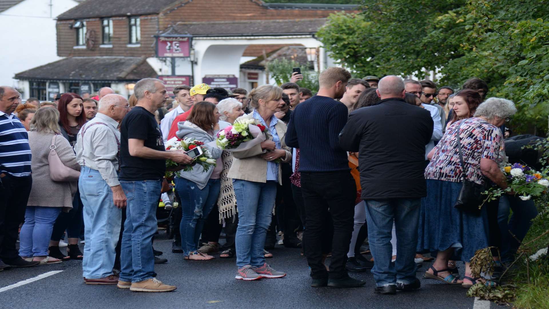 Family and friends laying floral tributes on Canterbury Road, Herne