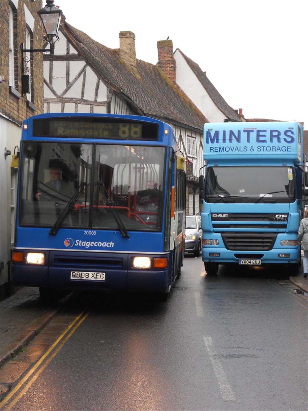 Bus has to drive on pavement due to parked lorry.