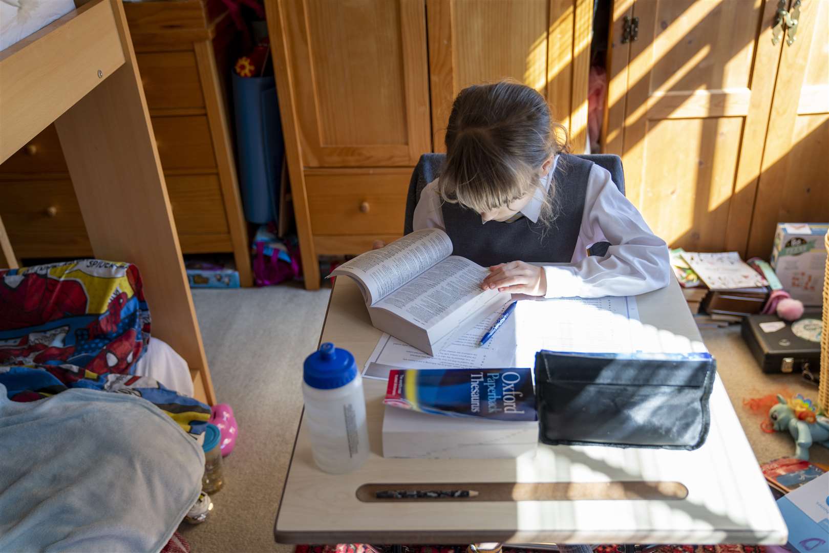 Emily, nine, sits at her desk at home on the first day of home schooling after schools shut (Giles Anderson/PA)