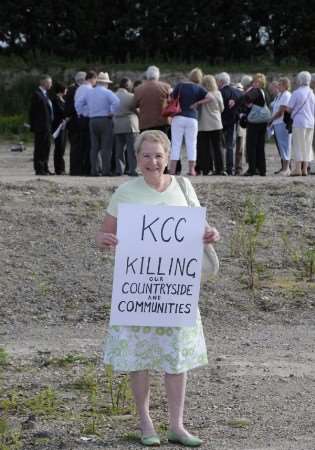 Jill Jelly and her protest sign as councillors inspect the site of the proposed recycling plant at Sellindge