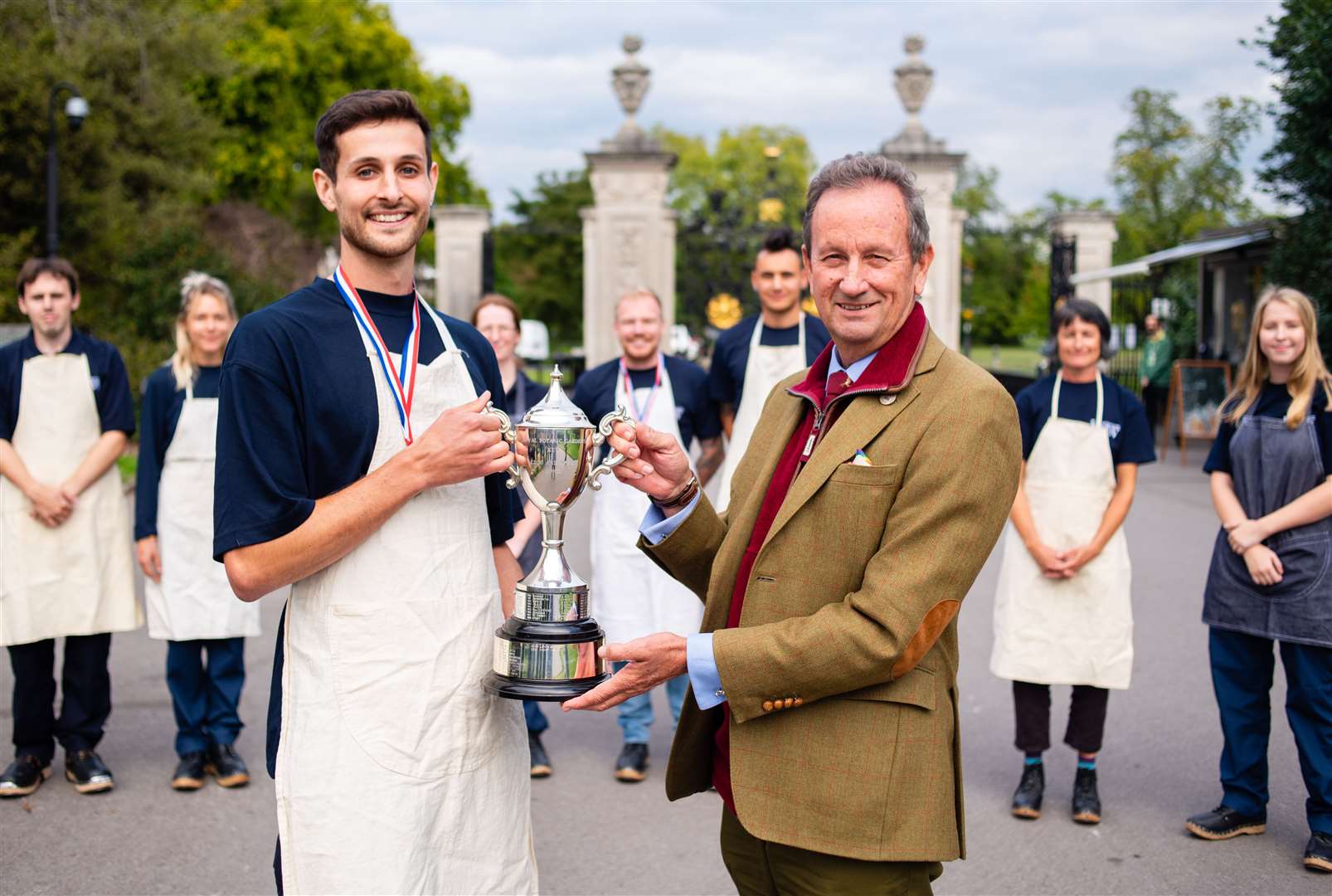 Director of gardens Richard Barley presents winner Louis with a trophy (RBG Kew)