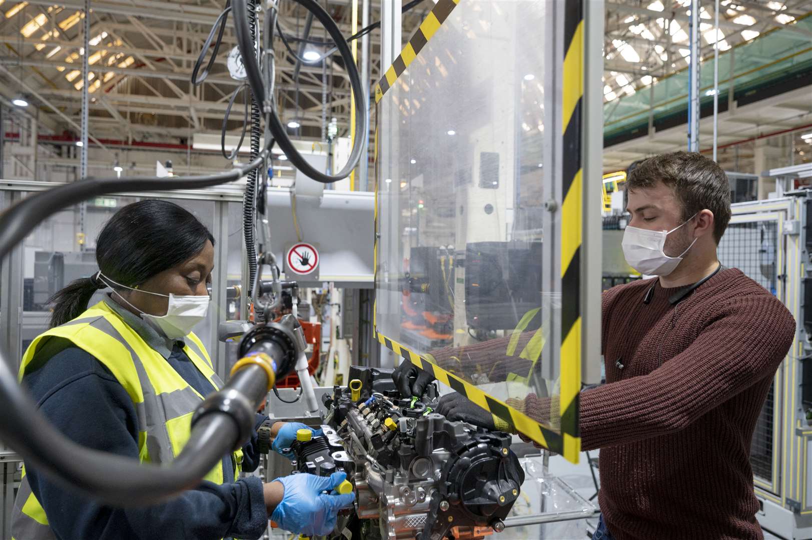 Ford workers wearing masks and separated by a screen at the Dagenham Engine Plant in Essex where initial production has resumed (Ford/PA)