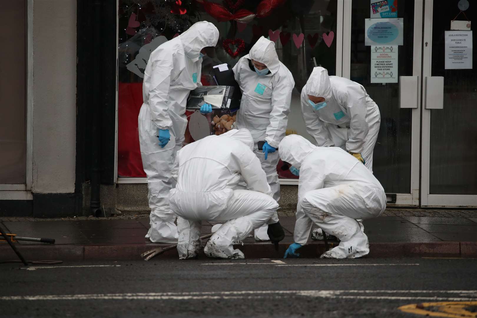 Police forensics officers search a drain in Portland Street, Kilmarnock, where Ms Anderson was stabbed (Jane Barlow/PA)