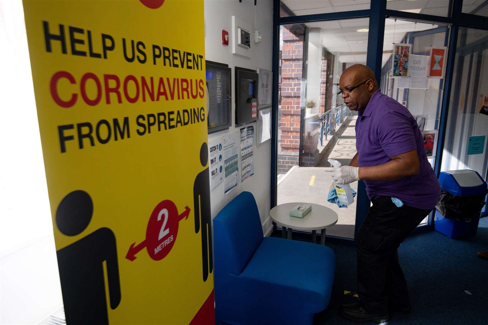 A cleaner disinfects the reception (Jacob King/PA)