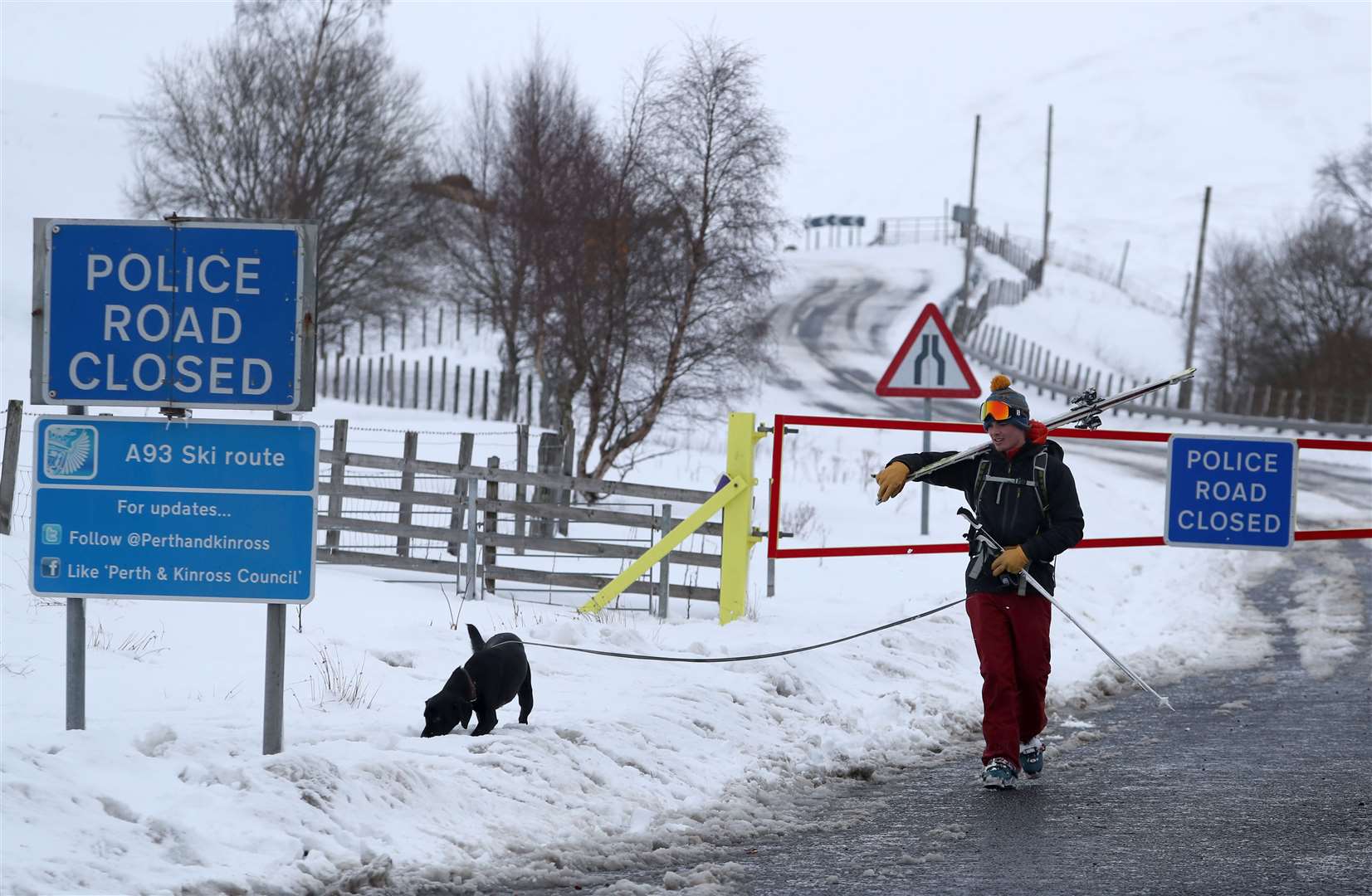 Dog-walking along the A93 near the closed snow gates at the Spittal of Glenshee (Andrew Milligan/PA)