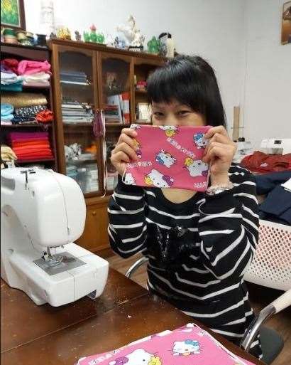 Ritika Gurung models one of the masks at her sewing machine