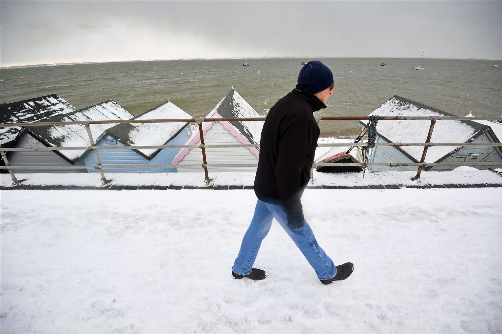 A man walks on the snow-covered seafront at Thorpe Bay, Essex (Victoria Jones/PA)