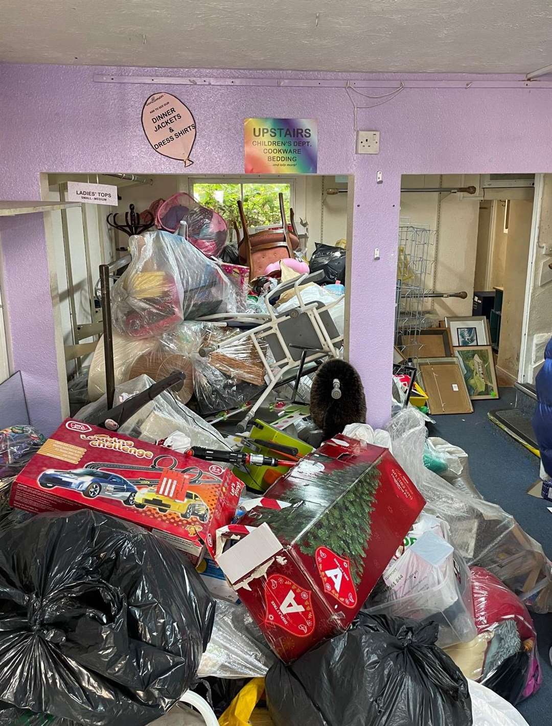 Behind the black-out window of the Save the Children store items fill the property