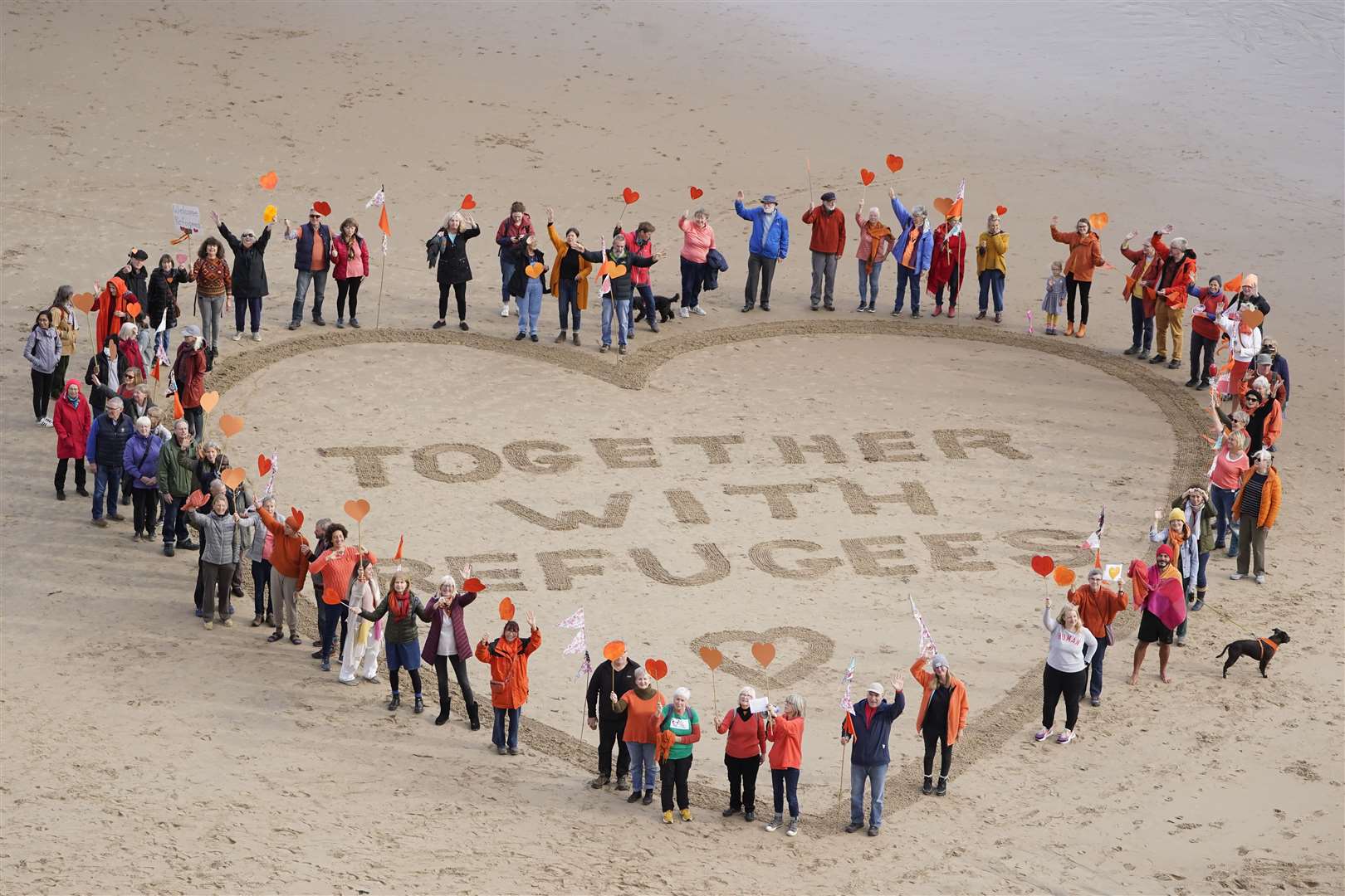 Demonstrators on King Edward’s Bay Beach in Tynemouth to show solidarity for refugees and to protest against the Nationality and Borders Bill which is currently going through parliament (Owen Humphreys/PA)