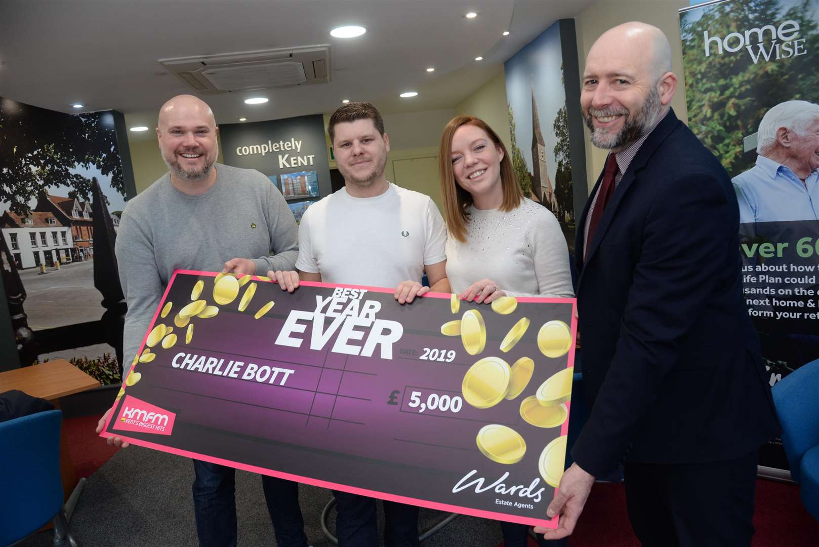 KMFM's Andy Walker and Richard Gunson of Wards, right present the cheque for £5000 to Charlie and Nikki Bott from Margate at Wards in Birchington on Sunday. Picture: Chris Davey. (7238555)