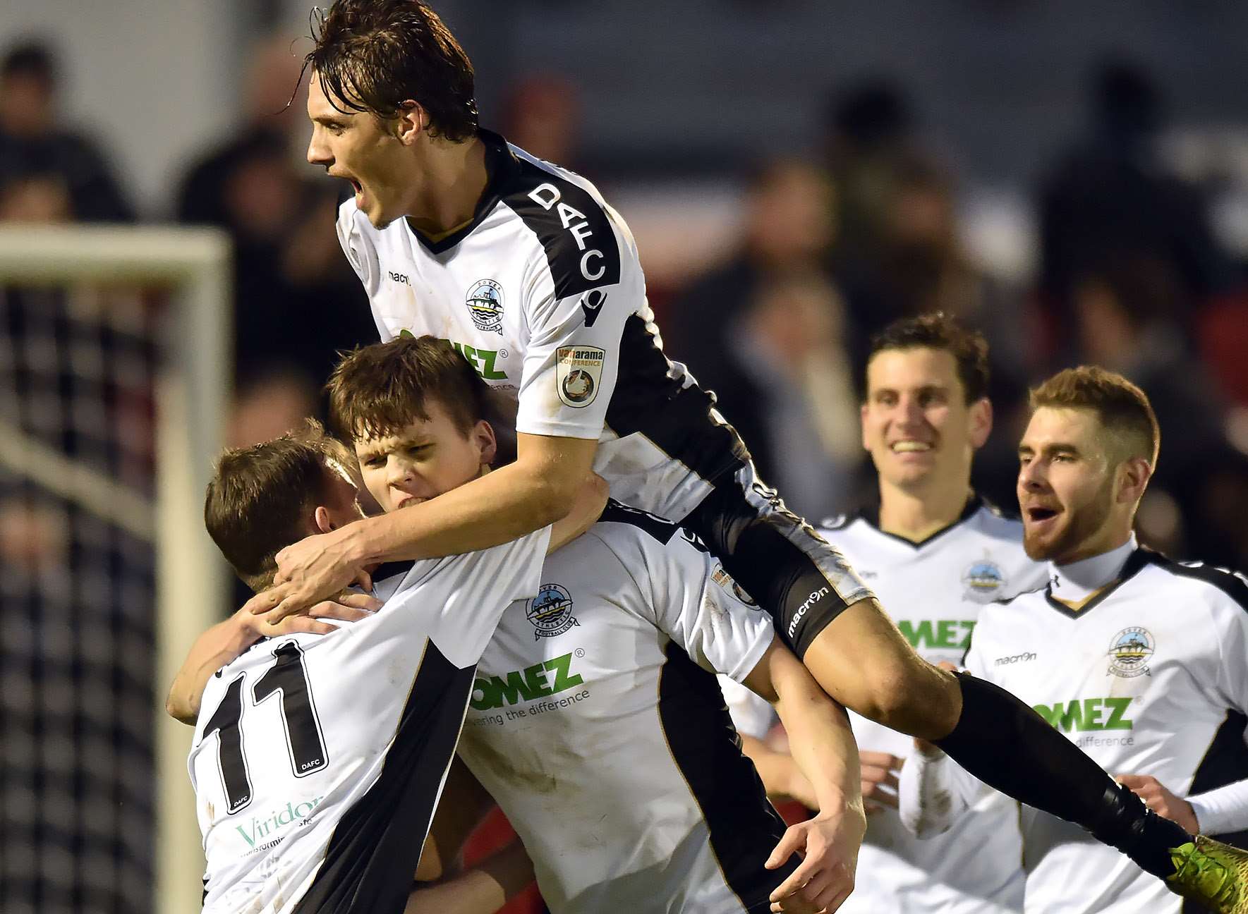 Dover defender Sean Raggett is swamped by his team-mates after scoring at Welling on New Year's day. Picture: Keith Gillard