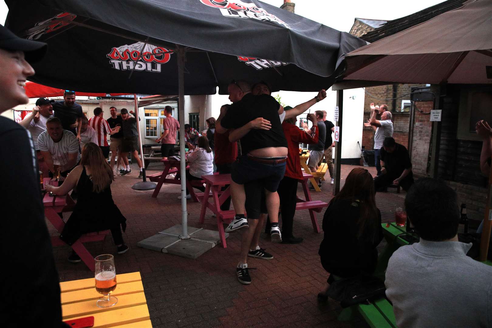 Brentford fans celebrate in a beer garden after their side scored a goal (Aaron Chown/PA)