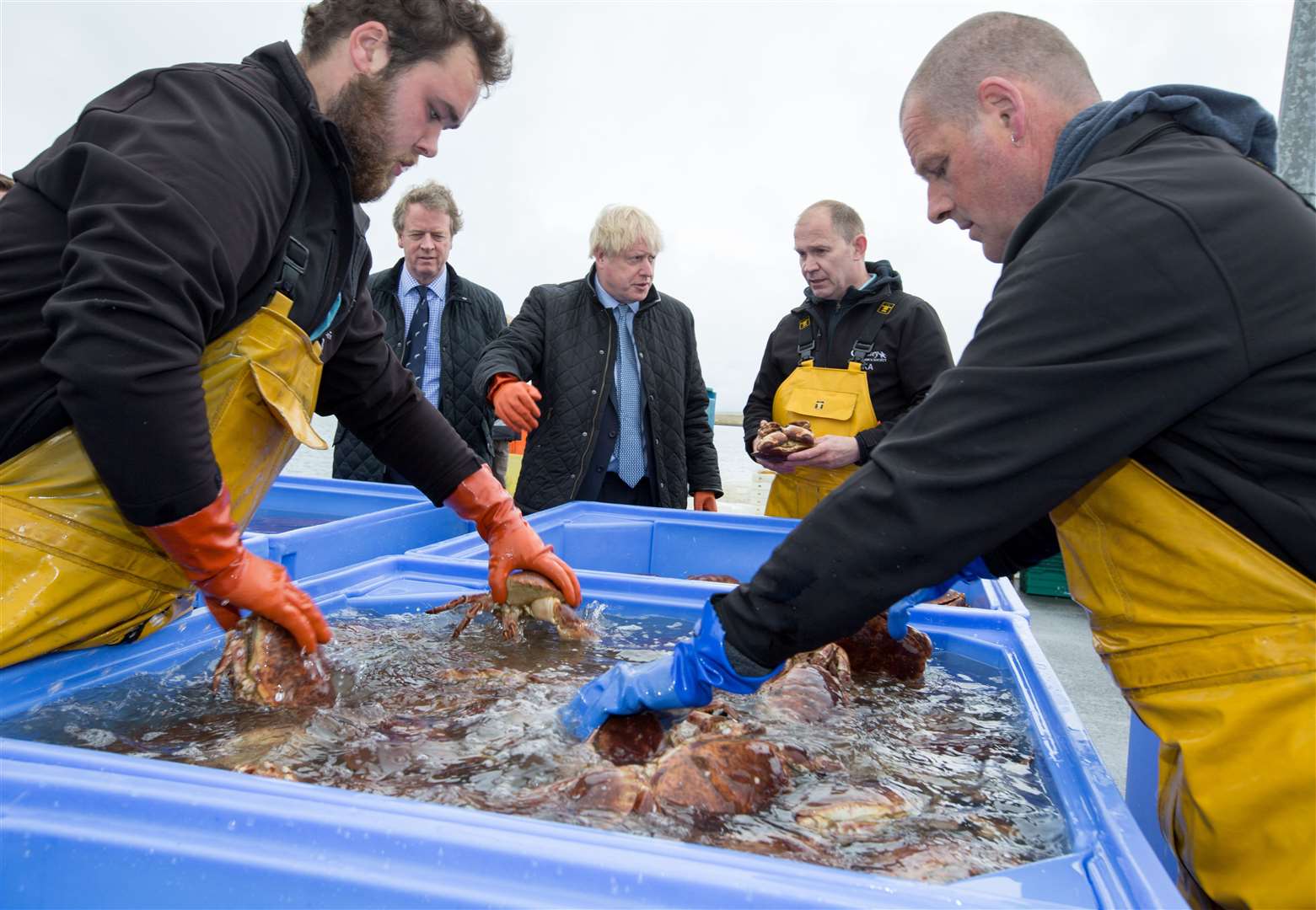 Prime Minister Boris Johnson and Scottish Secretary Alister Jack speak to Karl Adamson, of the Orkney Fishermen’s Society, as they search for crabs (Robert Perry/PA)